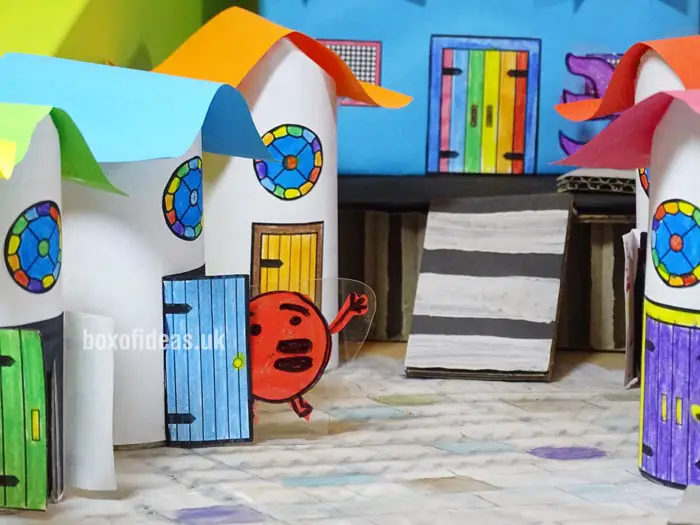 Colorful cardboard tube houses for a recycled town project. A fun DIY kids craft toy made out of recycling #kidscrafts #tubecrafts