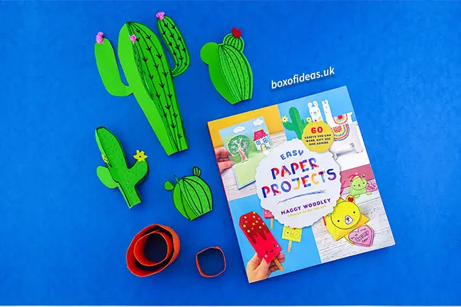 Resting 3-d cactus crafts next to the book 60 easy paper projects #papercraft #kidscraft #craftsforkids #cactus #easycrafts #boxofideas