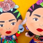 Two Frida Kahlo crafts for kids made with paper plates posing as if they were taking a selfie.